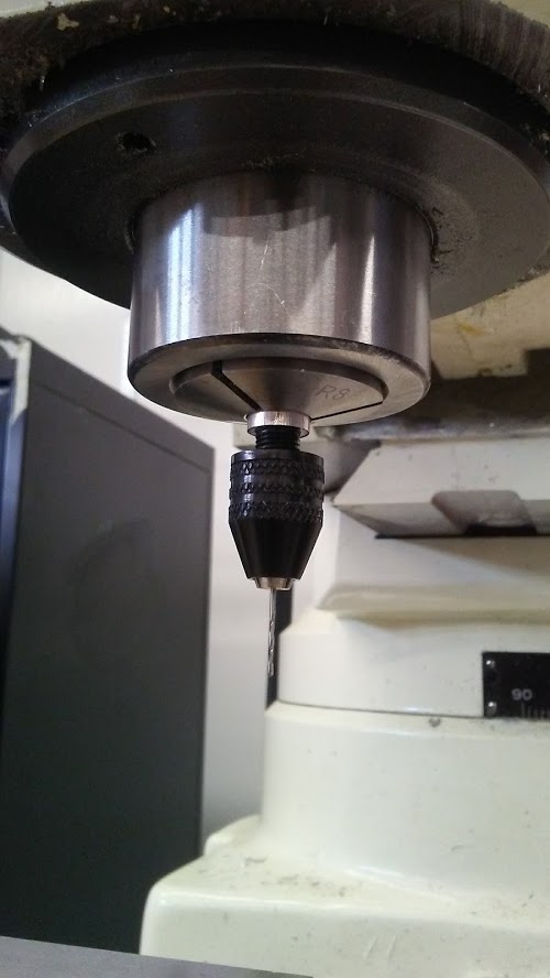 a small drill bit mounted in a collet, mounted in a collet