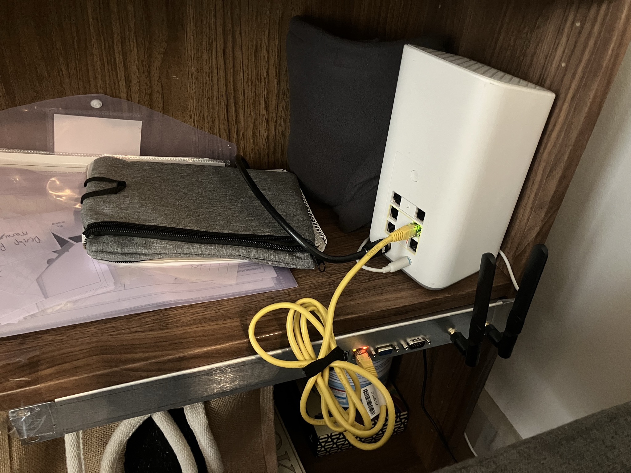 The assembled router attached to the bottom of a shelf in a bookcase.